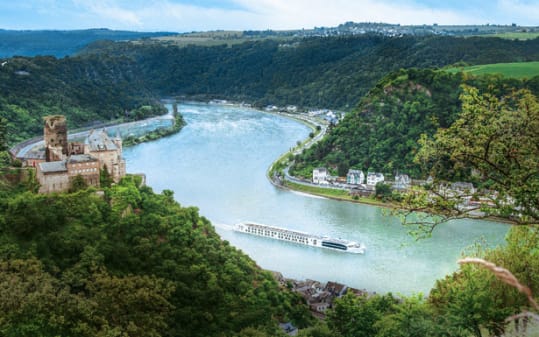 River Beatrice sailing on a European river surrounded y lush scenery and a small town